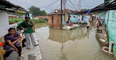 Residents of a low-lying neighborhood watch as floodwaters submerge their area following heavy rains in Kanpur, India, on Sept. 22, 2026.