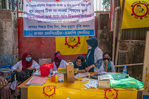 Healthcare workers continue a measles-rubella vaccination campaign at a makeshift station outside the damaged Radda MCH-FP Centre in Mirpur-1