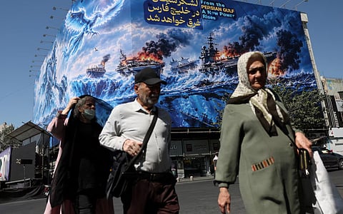 People walk past a billboard about the Strait of Hormuz, on a building in Tehran, Iran, September 16, 2026. 