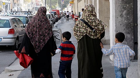 Two Muslim women wearing hijabs walk with children in Milan October 7, 2009.