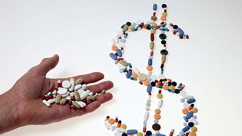 Pharmaceutical tablets and capsules are arranged in the shape of a US dollar sign on a table in this picture illustration taken in Ljubljana August 20, 2014.