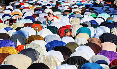 People pray along a street during the Eid holiday that marks the end of the Muslim holy month of Ramadan in New York, US