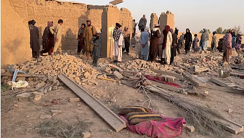 People stand on the rubble of a house that was damaged in what the Taliban said was a Pakistani airstrike in Garmsir district in Helmand province, Afghanistan, October 1, 2026. Picture taken with a mobile phone.