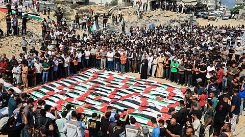 Mourners attend a mass funeral for Palestinians whose bodies were recovered from the rubble of a residential building hit in an Israeli strike in October 2023, according to the Civil Defence, in Gaza City October 1, 2026. 