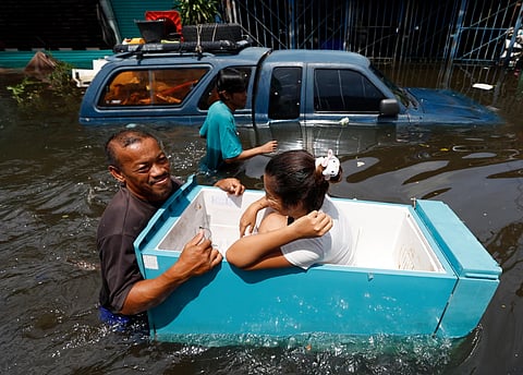 A resident uses a floating fridge as a boat. 