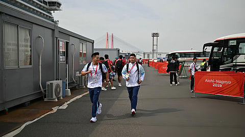 Asian Games athletes walk to buses beside the Costa Serena cruise ship, their floating accommodation, at Port Messe Nagoya.