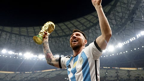 Argentina's Lionel Messi celebrates winning the World Cup with the trophy.
