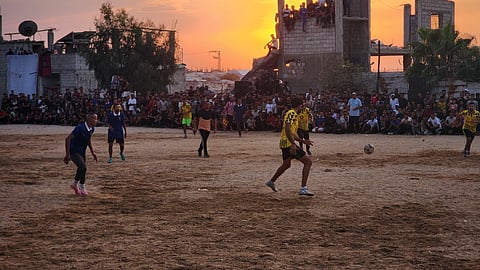 Displaced Palestinians gather around a makeshift football pitch in Khan Yunis, southern Gaza Strip, Palestine, on October 2, 2026, amid widespread destruction of sports facilities following Israeli attacks.