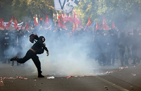 A masked protester on the fringes of the protest march in Paris, October 6, 2026. 