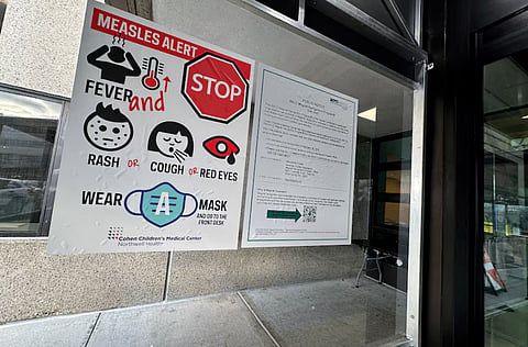 A measles alert sign hangs outside the entrance to the Cohen Children's Medical Center in New Hyde Park, New York, U.S., March 14, 2025.