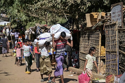 Rohingya youths carry sacks of relief aid in Kutupalong refugee camp, Ukhia, Cox’s Bazar, Bangladesh, Dec 20, 2025.