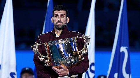 Serbia's Novak Djokovic reacts with the trophy after winning the final against Australia's Alex de Minaur.