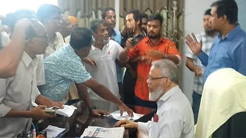 Rajshahi Medical University Vice-Chancellor Professor Jawadul Haque signs a resignation letter under pressure during an alleged assault by a group of BNP supporters at the university’s temporary office in Rajshahi on Tuesday.