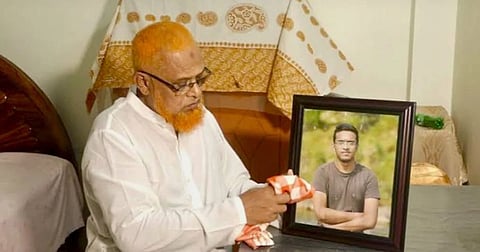 Abrar Fahad's father Md Barkat Ullah with his son's photo