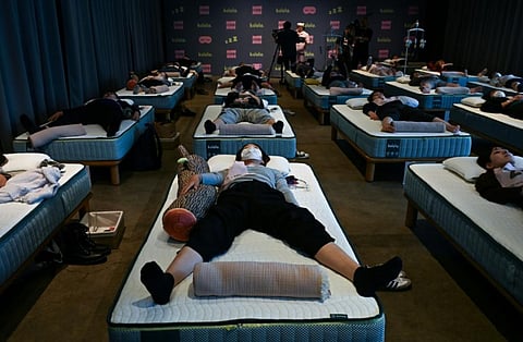 Attendees take part in a sleep competition organized by a mattress brand in Tokyo on Monday.