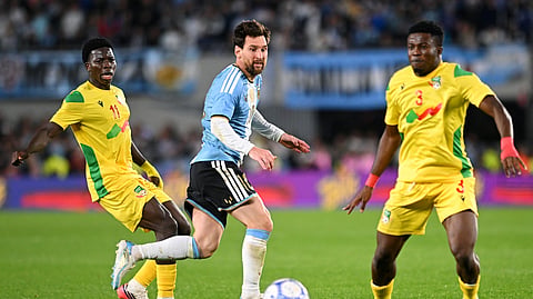 Argentina's Lionel Messi in action with Benin's Yamirou Ouorou (R).