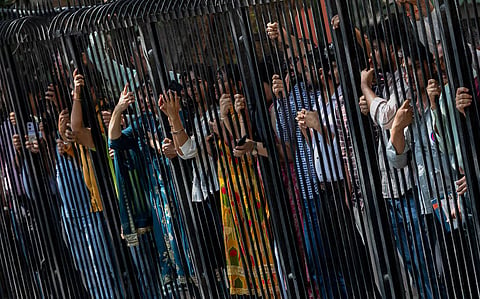 People look on from inside their office premises as Indian opposition party leaders take part in a protest demanding the resignation of Chief Election Commissioner Gyanesh Kumar in New Delhi, India, October 6, 2026. 