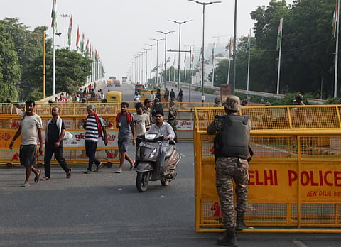 Commuters cross a checkpoint as police officers stand guard on the second day of a protest planned by the Cockroach Janta Party (CJP) seeking the resignation of India's Chief Election Commissioner, Gyanesh Kumar, in New Delhi, India, October 11, 2026. 