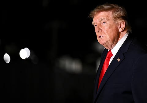 US President Donald Trump looks on while walking as he returns to the White House after travelling to Ohio, in Washington, DC, US, October 12, 2026.