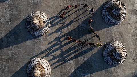 A group of children from working-class and displaced families play in a circle among huge bamboo-made covers, known as toka, at a rice mill in Ashuganj, Brahmanbaria.