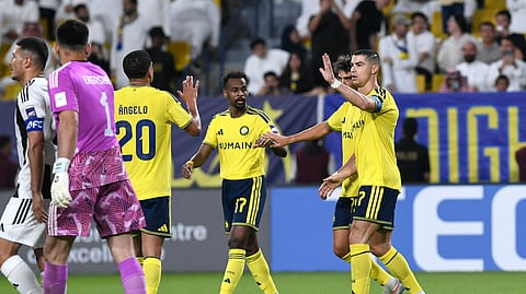 Al Nassr's Cristiano Ronaldo and Angelo celebrate their third goal, an own goal scored by Neftchi Fergana's Anvar Gofurov.