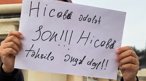 Students protesting with placard demanding end to the discriminatory rule