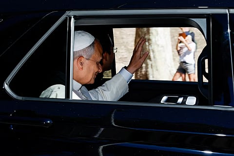 Pope Leo waves from a car window as he leaves the Vatican, ahead of his hospitalization for surgery to remove a lung nodule, in Rome, Italy, October 13, 2026.