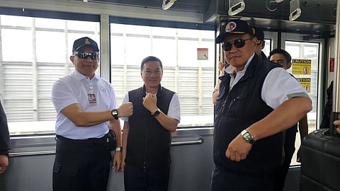 Anutin Charnvirakul, right, with Interior Ministry officials showing their watches.