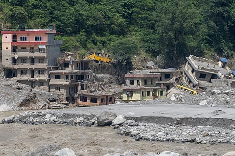 Multistorey buildings lie partially buried, damaged or tilted amid massive deposits of mud, rocks and debris after devastating flash floods and landslides swept through a riverside settlement in Nepal