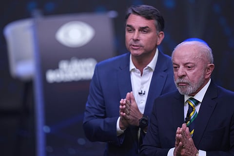 Brazilian President Luiz Inacio Lula da Silva, front, who is running for reelection, and opposition presidential candidate Sen. Flavio Bolsonaro hold their hands together during a televised presidential debate one week before the presidential runoff election in Sao Paulo, Brazil, Sunday, Oct 18, 2026.