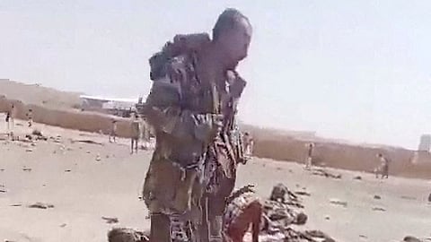 A screengrab from a video shows a person walking near bodies in the aftermath of a Houthi attack on Yemeni government military camp in Shabwa, Yemen, October 19, 2026.