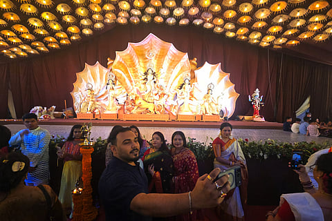 Visitors take photographs at a Durga Puja celebration in Dhaka, capturing moments of joy and a festival that brings the neighbourhood together.