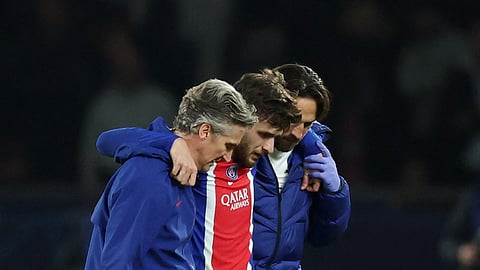 Paris St Germain's Khvicha Kvaratskhelia leaves the pitch after sustaining an injury.