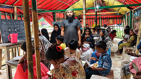 Mizanur Rahman stands among children at Amrao Manush Pathshala in Habiganj, where 110 underprivileged students receive free education