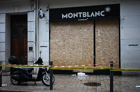 A vandalized Montblanc store with its broken windows boarded up is cordoned-off following clashes that erupted during a national day of demonstrations against the cost of living and rising fuel prices, in Marseille, France, October 19, 2026. 