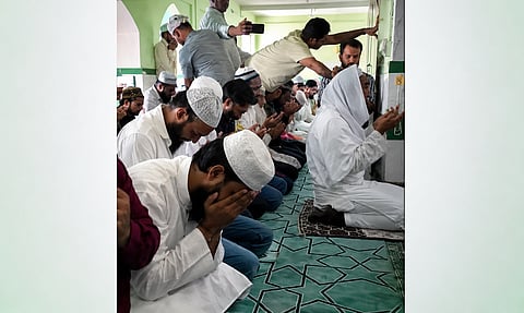 Worshippers stand alongside the imam as they pray for the mosque’s preservation and the restoration of their dignity.