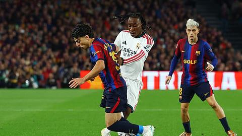 Real Madrid's Yan Diomande in action with FC Barcelona's Xavi Espart.