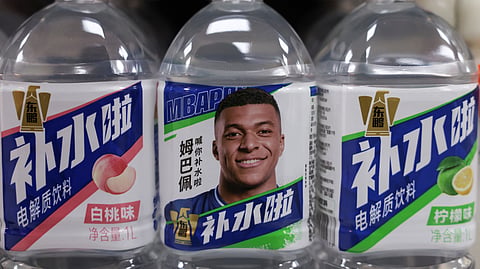 Bottled drinks by Eastroc Beverage with images of French football player Kylian Mbappe are displayed on a shelf at a store, in Beijing, China.