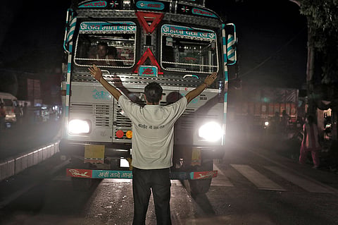 A member of the Bhartiya Gau Raksha Dal cow vigilante group raises his arms to stop a truck at a roadblock set up in the northern Indian city of Chandigarh in early July 2017