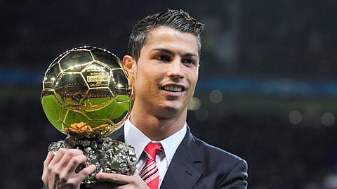 Cristiano Ronaldo poses with the Ballon D'Or trophy.