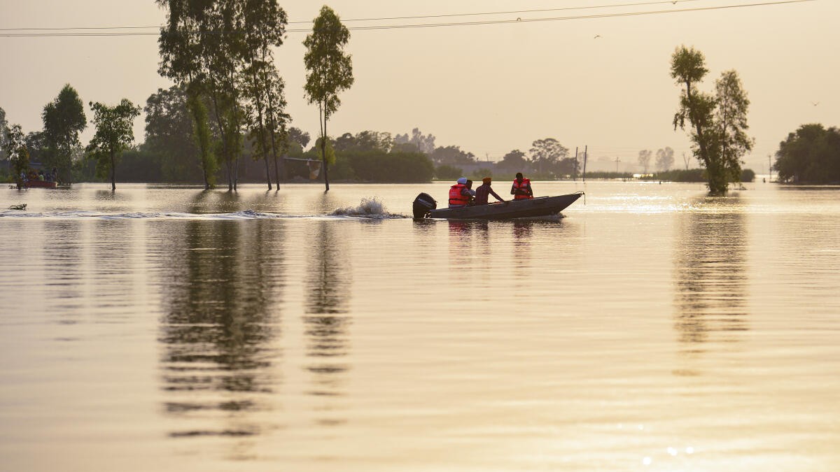 Rescue officials help residents shift to a safer place from a flood-affected area as the swollen Beas river inundates nearby areas following heavy monsoon rains, near Jalandhar.