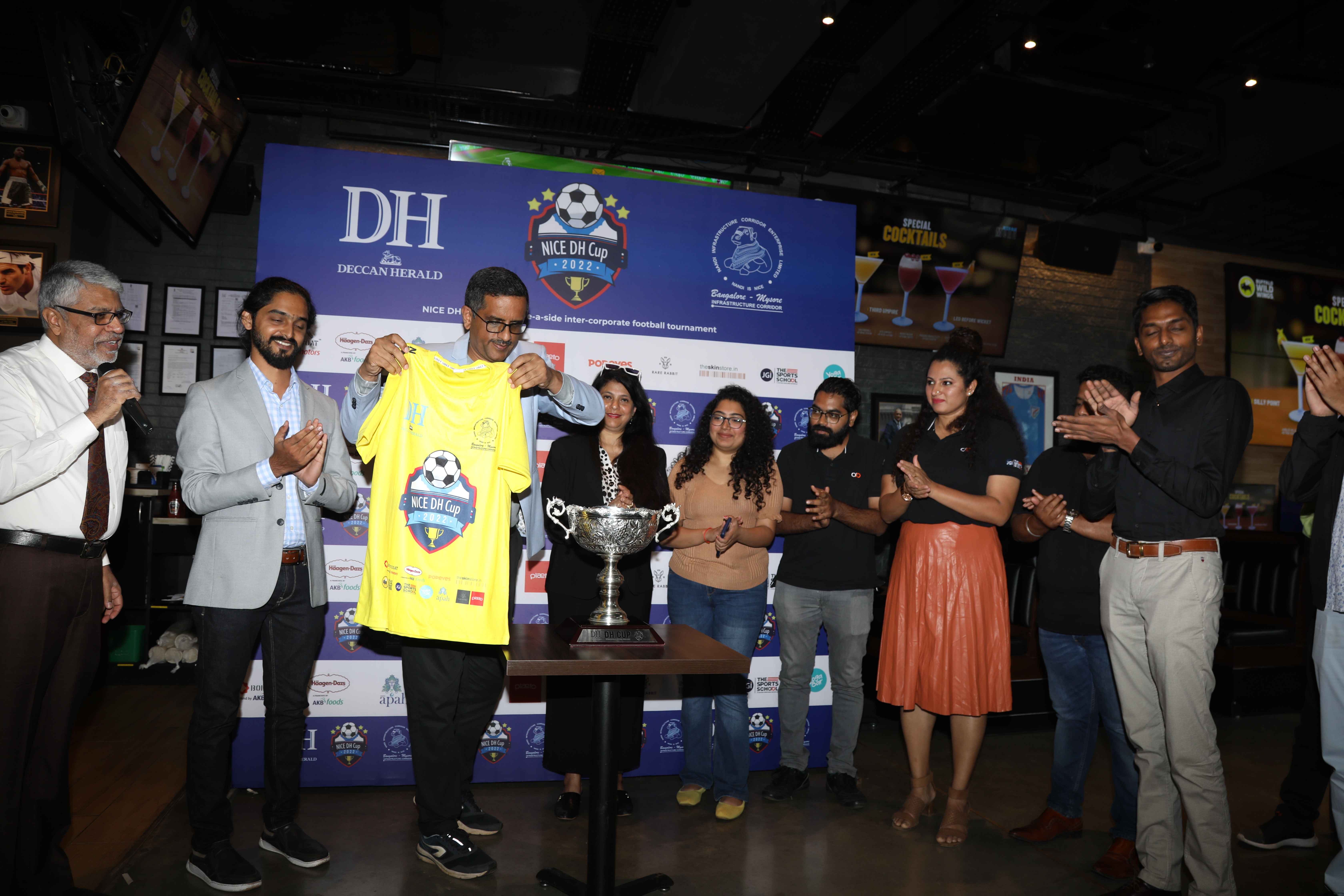 Sitaraman Shankar, CEO, The Printers Mysore Pvt Ltd unveils the NICE DH Cup along with the sponsors of the tournament