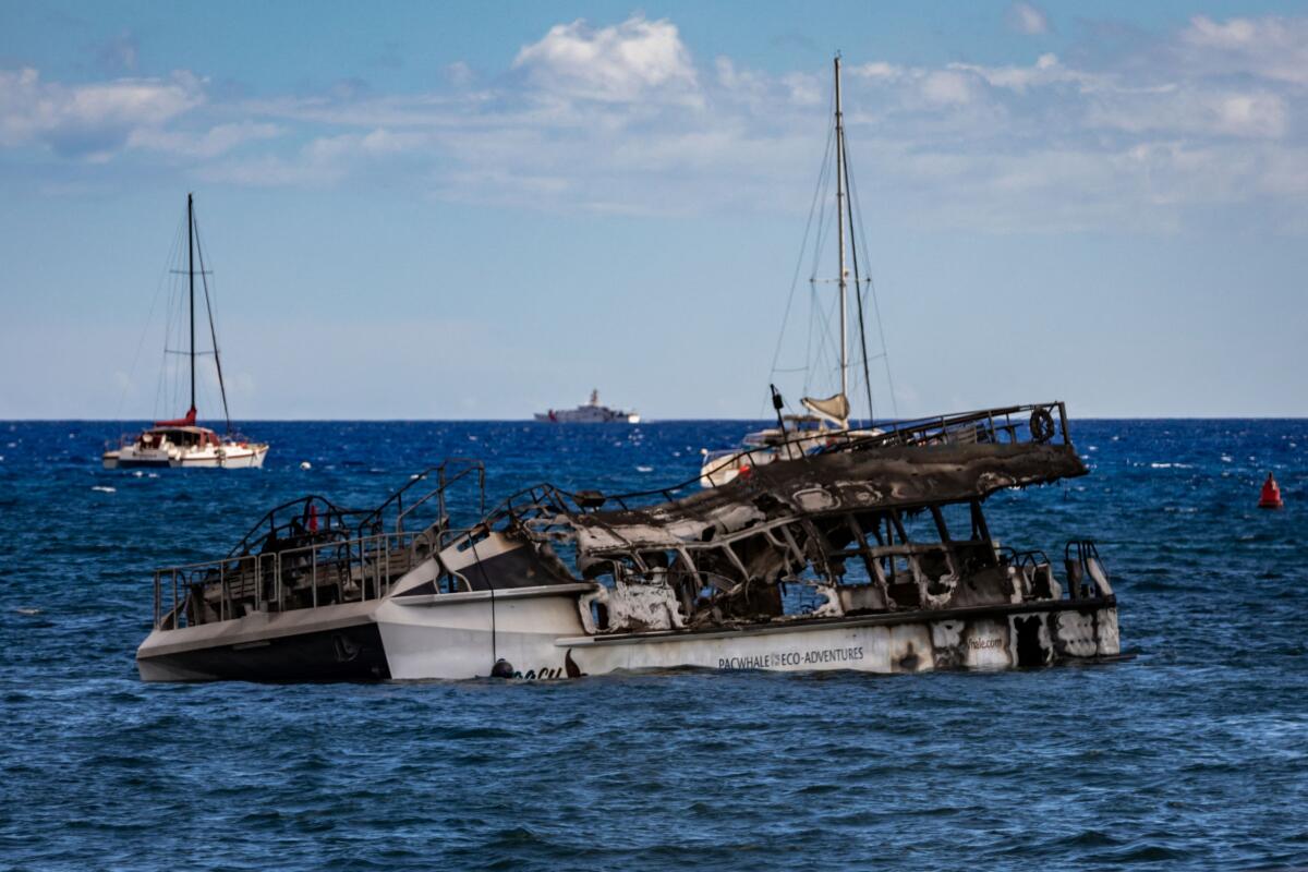 A PacWhale Eco-Adventures Catamaran damaged by Maui wildfires lies offshore in Lahaina, Hawaii. 