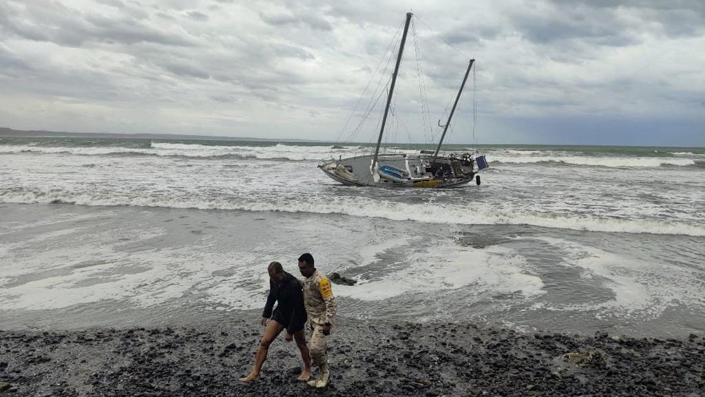 A member of the Mexican Army assists a man during the application of Plan DN-III-E in the Baja California peninsula through the pass of Tropical Storm Hilary in this undated handout photo provided by the National Defence Secretary (SEDENA).