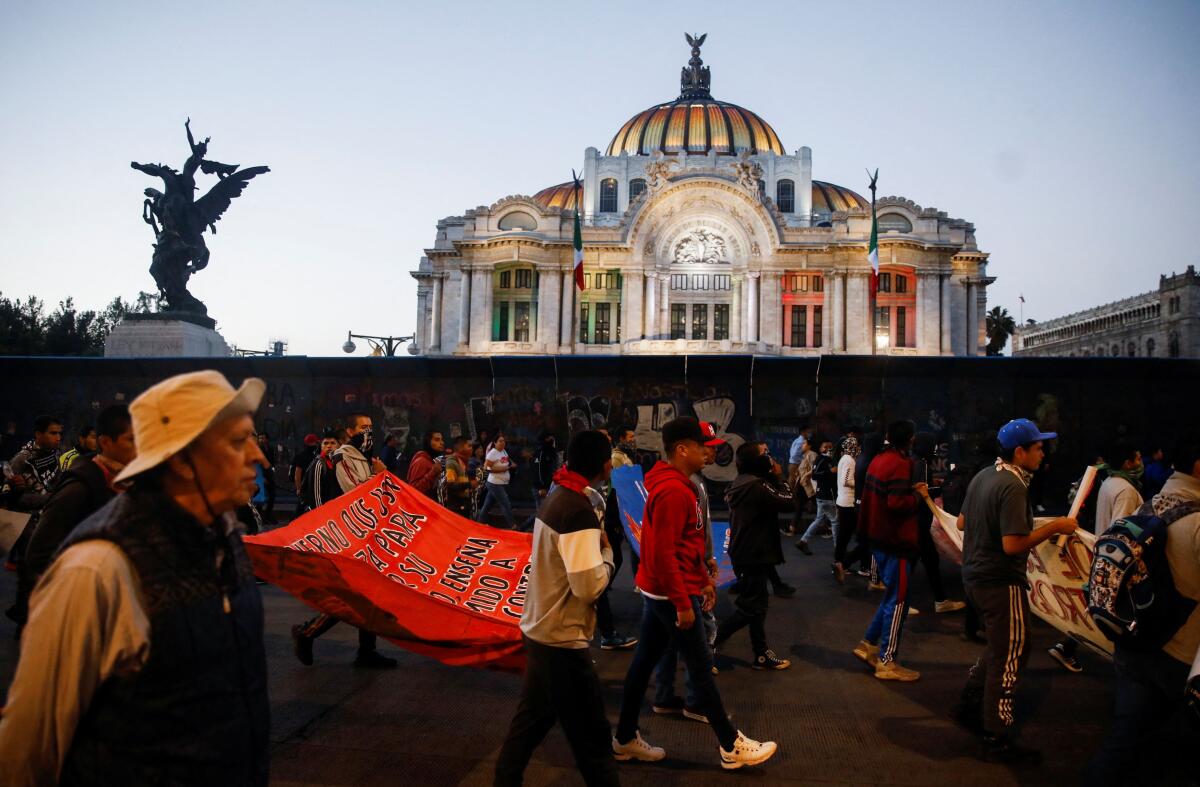 Demonstrators walk during a protest to mark the 9th anniversary of the 43 Ayotzinapa Teacher Training College's students' disappearance, in Mexico City.