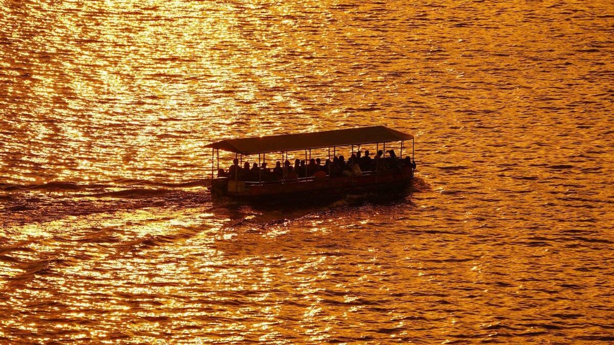 Tourists ride on a boat during sunset, at Anasagar Lake in Ajmer, Rajasthan. 