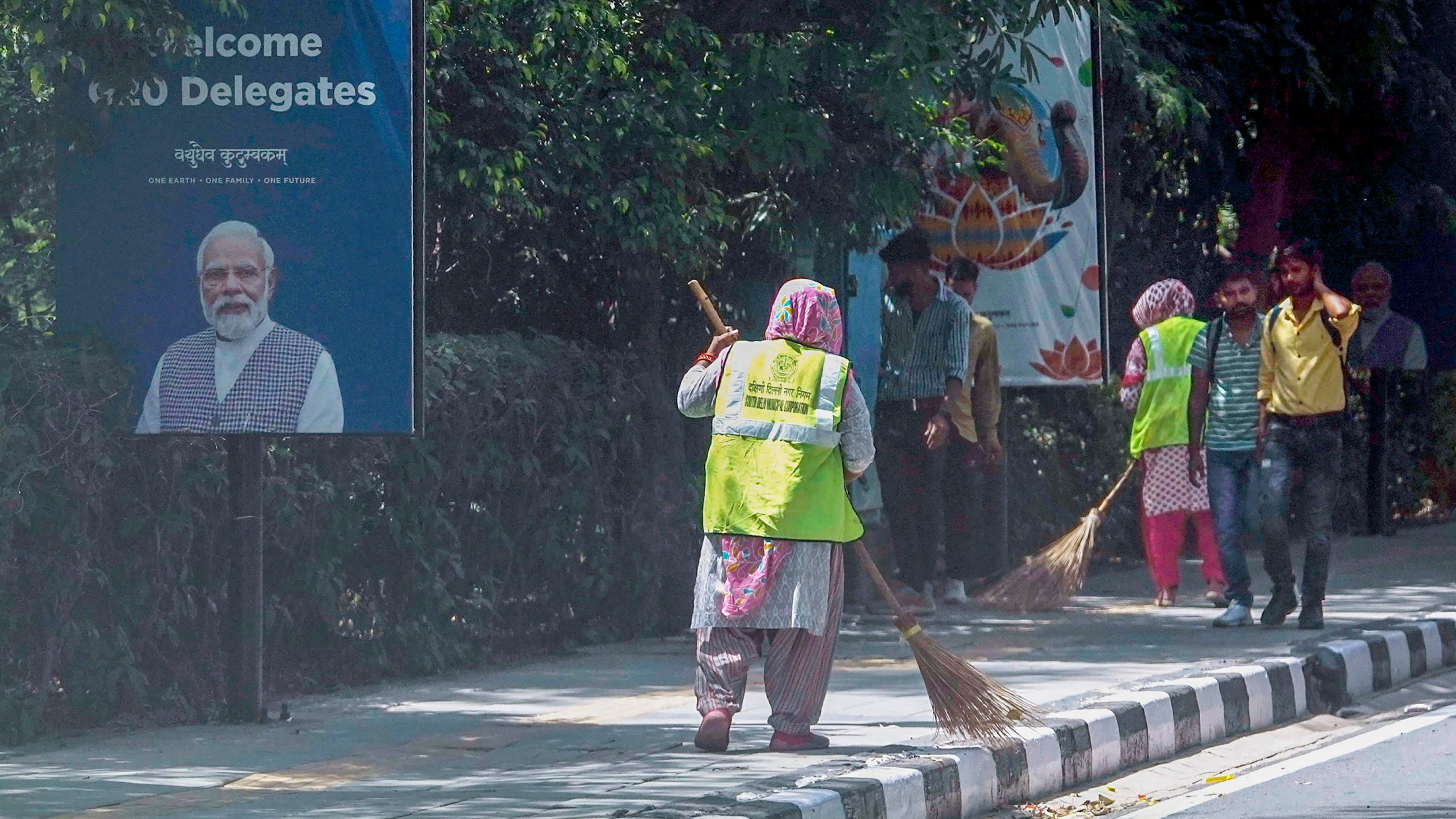 Workers clean a pavement near Rajghat in preparation for the upcoming G20 Summit, in New Delhi.