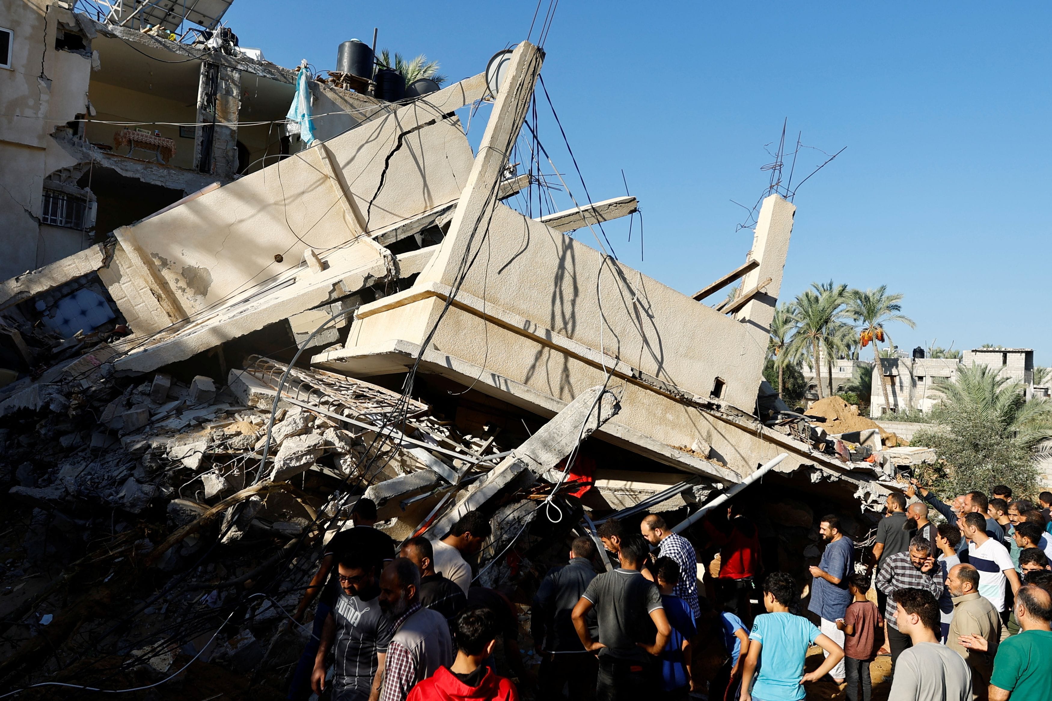 Palestinians search for casualties at the site of an Israeli strike on a house, in Khan Younis, in the southern Gaza Strip, October 21, 2023. 