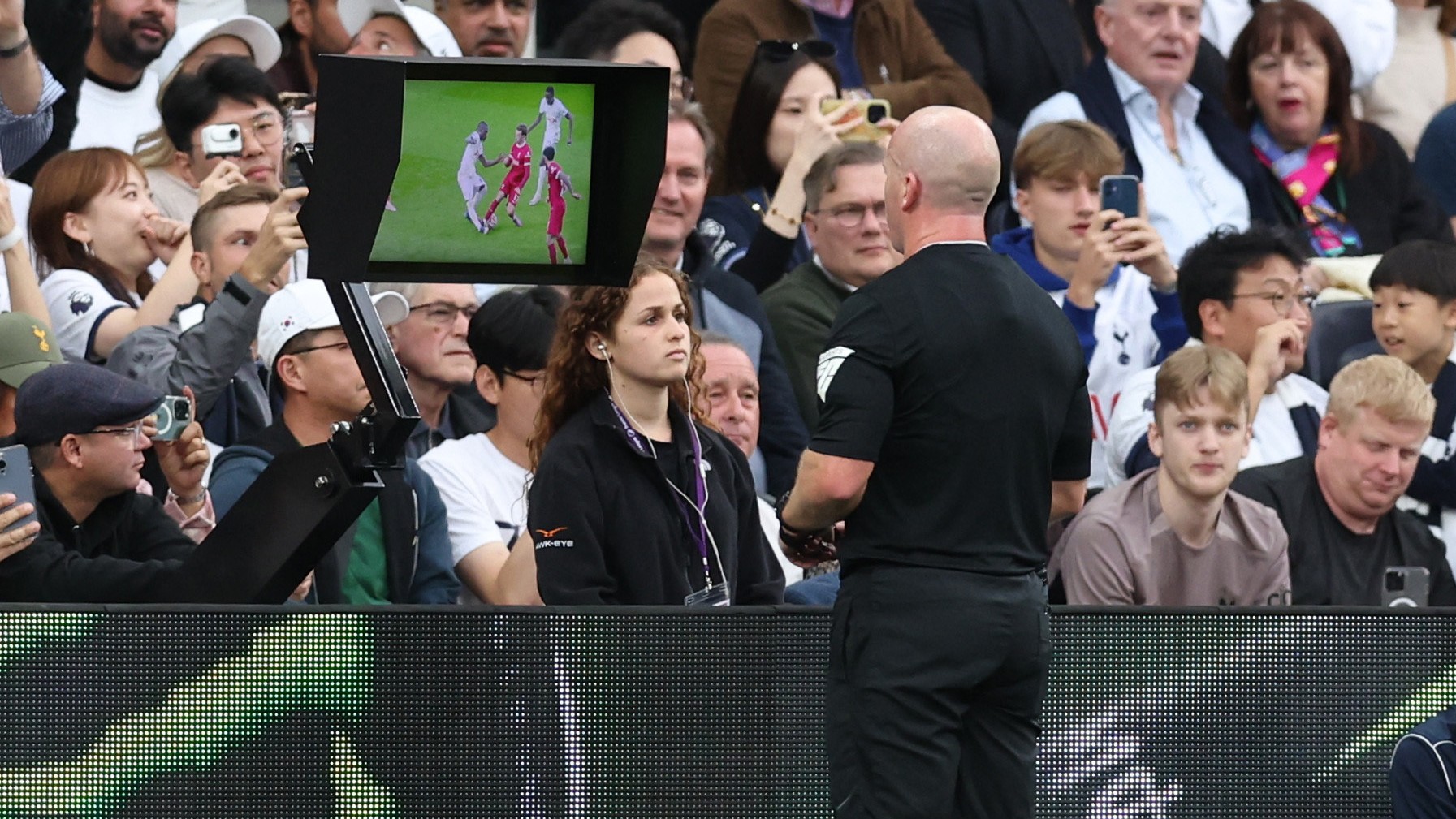 Referee Simon Hooper looks at the VAR monitor before giving Liverpool's Curtis Jones a red card.