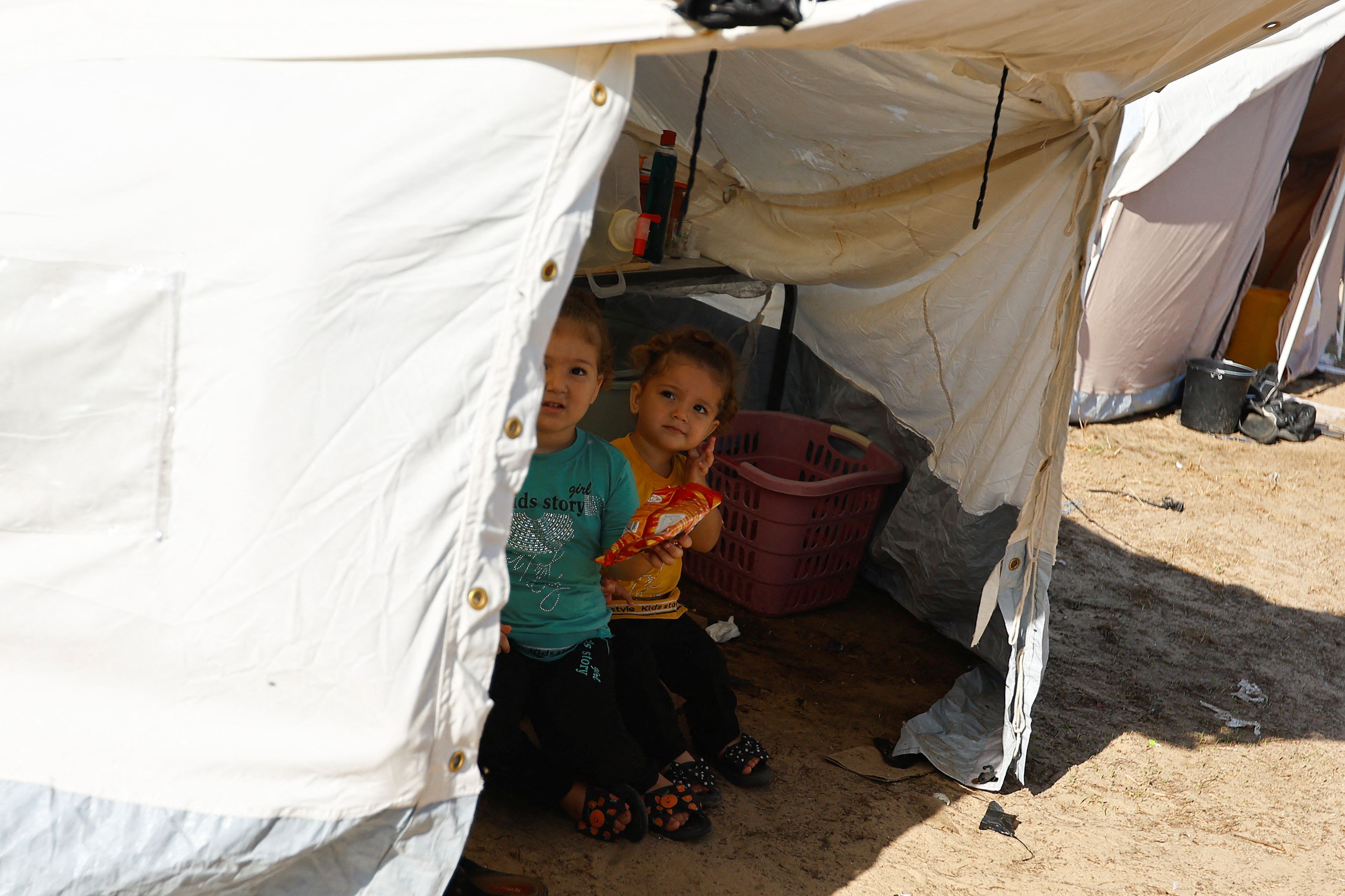 Palestinian children, who fled their house amid Israeli strikes, take shelter at a tent camp at a United Nations-run centre, after Israel's call for more than 1 million civilians in northern Gaza to move south, in Khan Younis in the southern Gaza Strip, October 26, 2023.